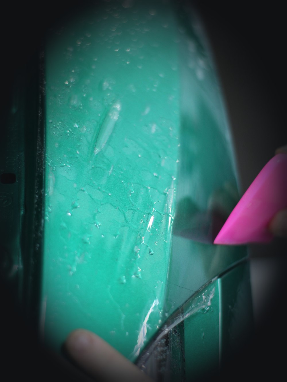 Installer applying paint protection film to a car's front end
